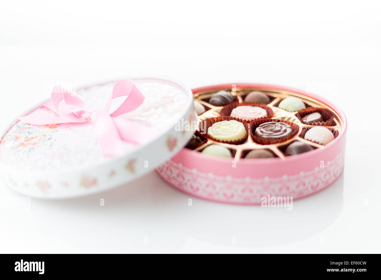 Boîte de chocolats rose avec ruban sur fond blanc Banque D'Images