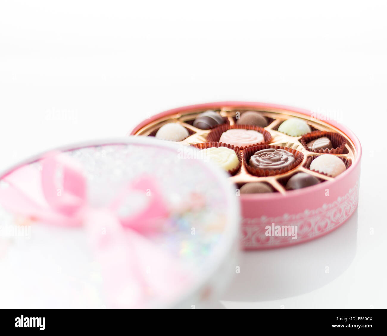 Boîte de chocolats rose avec ruban sur fond blanc Banque D'Images