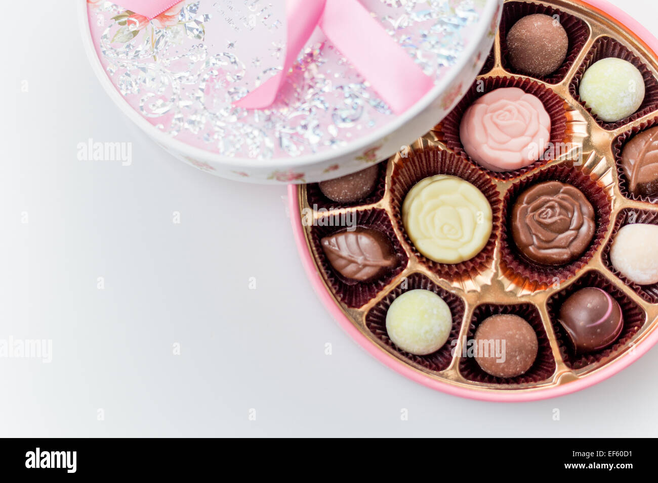 Boîte de chocolats rose avec ruban sur fond blanc, en plongée des Banque D'Images
