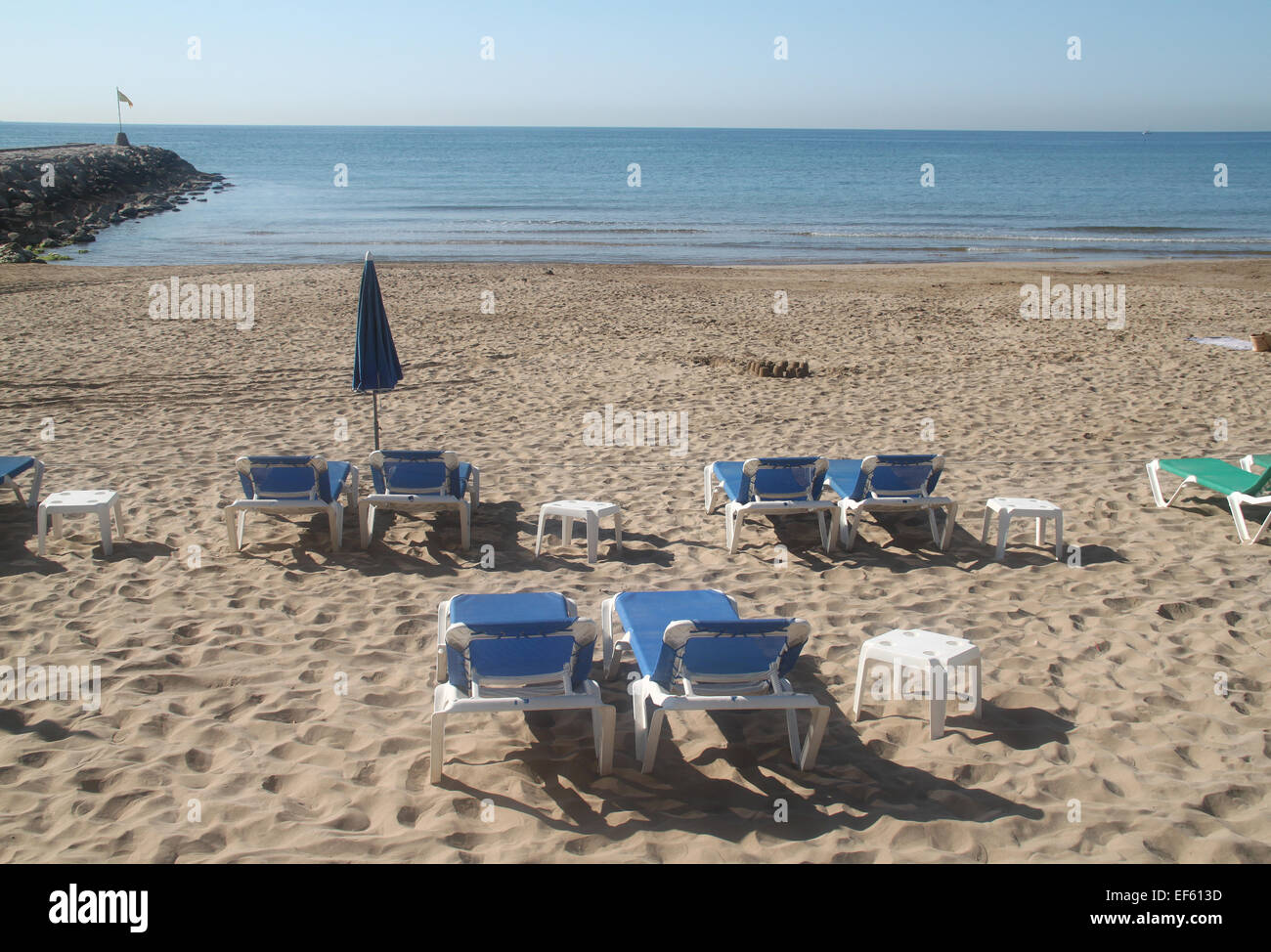 Des chaises longues et des tables en plastique vide sur la plage de Sitges, près de Barcelone, Catalogne Banque D'Images