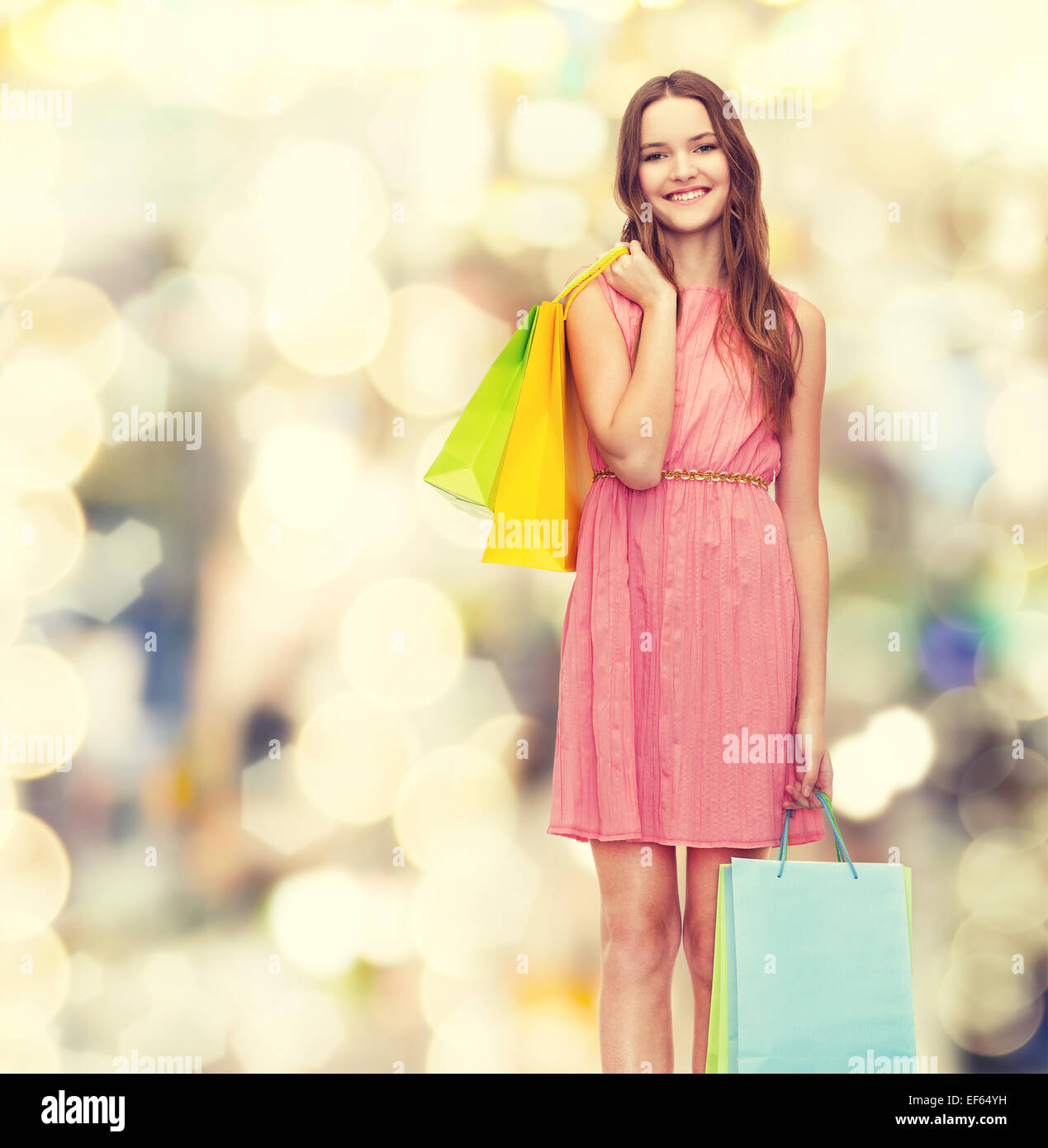 Smiling woman in dress avec de nombreux sacs de magasinage Banque D'Images