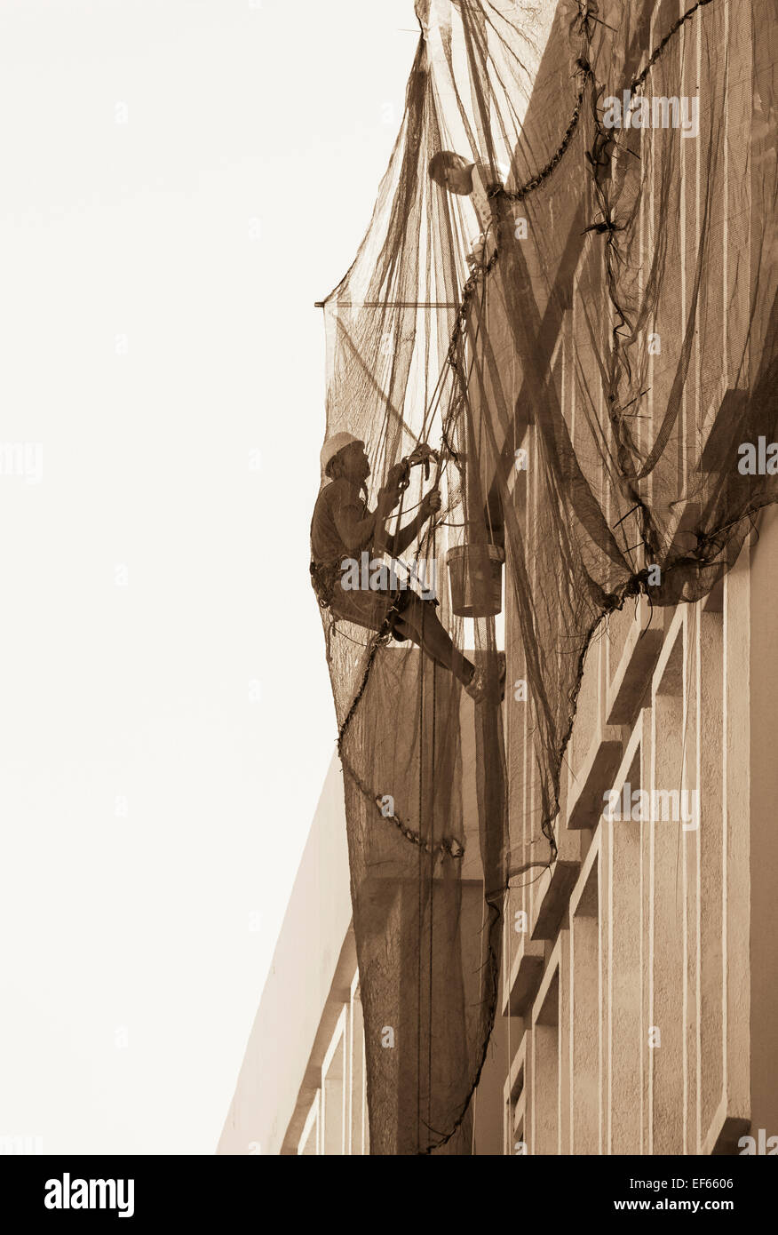 Workman ascending bloc d'appartement en Espagne la réparation de plâtre et peinture Banque D'Images