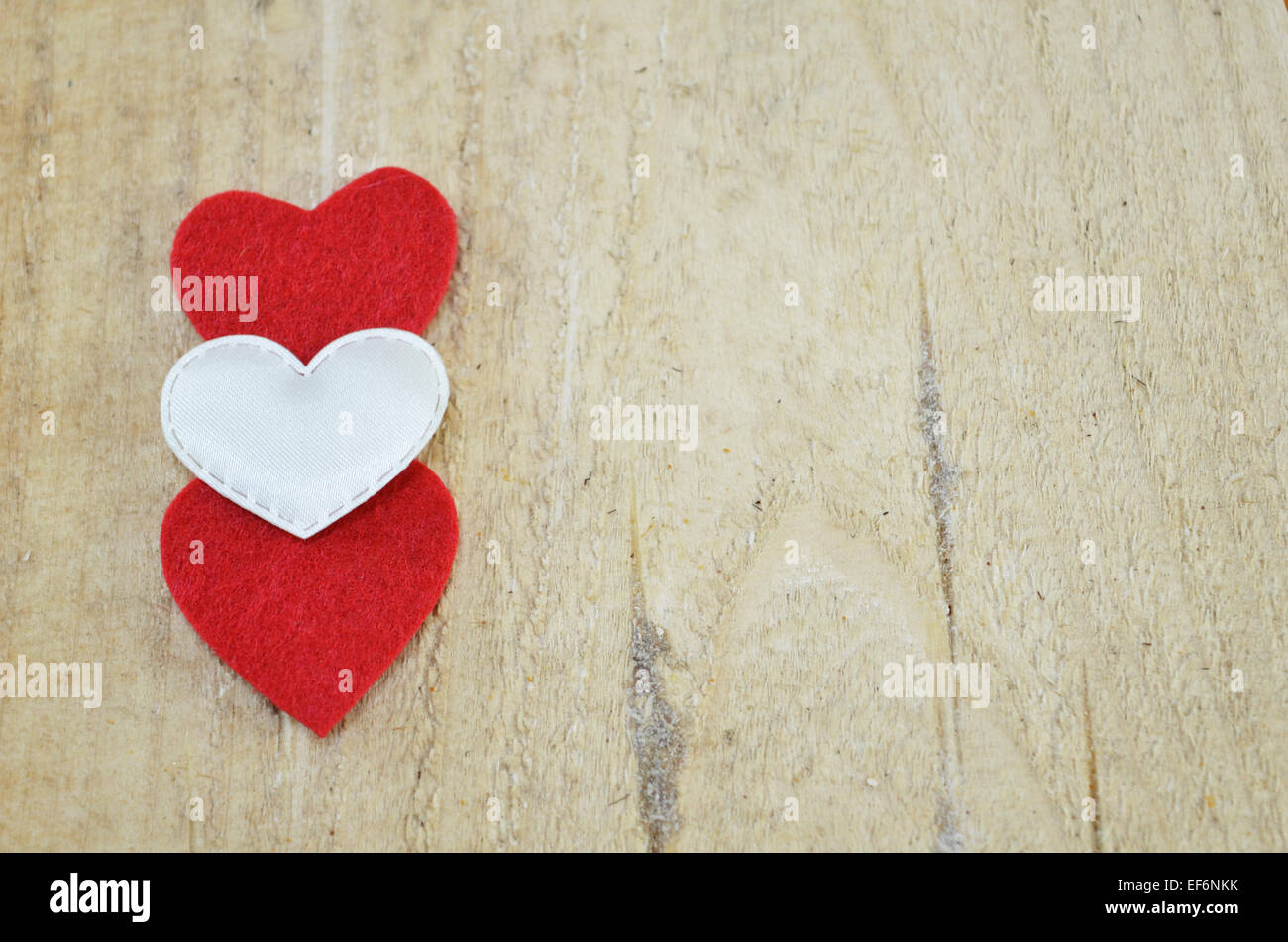Deux rouge et un coeur blanc sur une surface en bois Banque D'Images