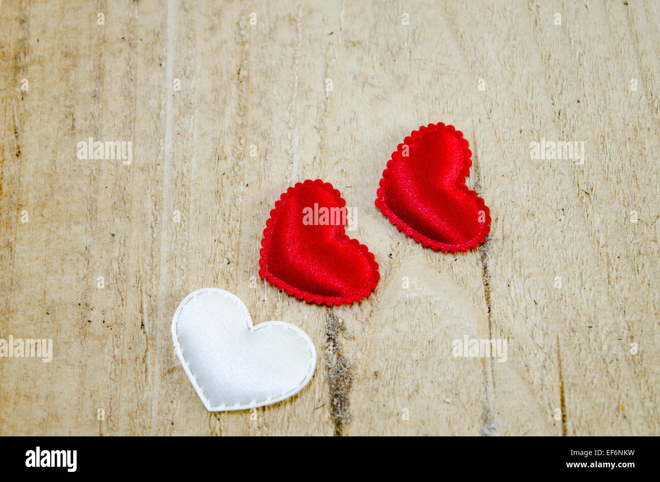Deux rouge et un coeur blanc sur une surface en bois Banque D'Images