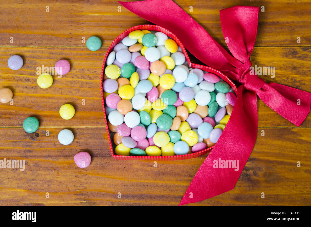 Chocolat colorés comprimés dans une boîte en forme de coeur Banque D'Images