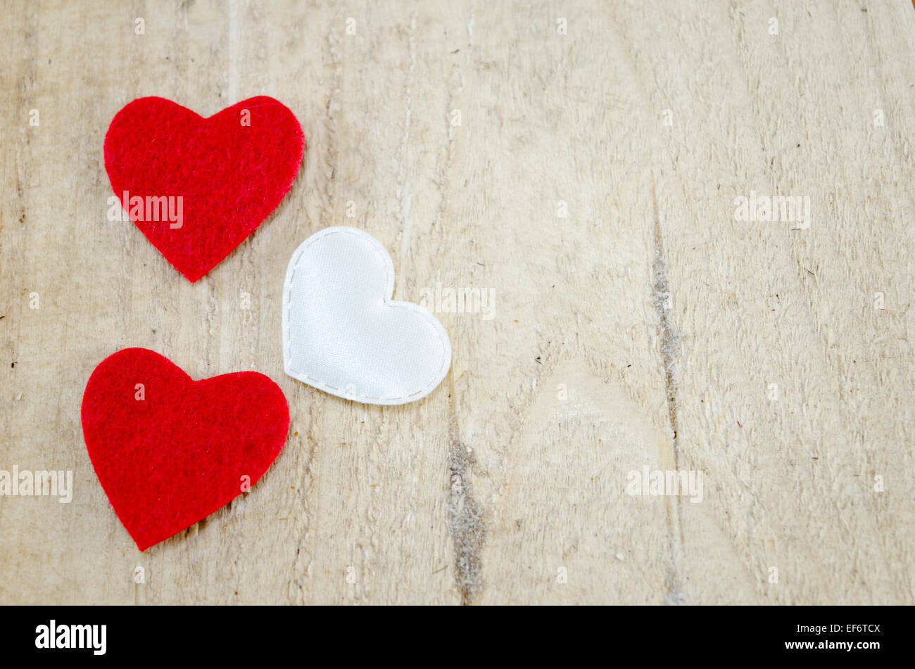 Deux rouge et un coeur blanc sur une surface en bois au hasard ordonné Banque D'Images