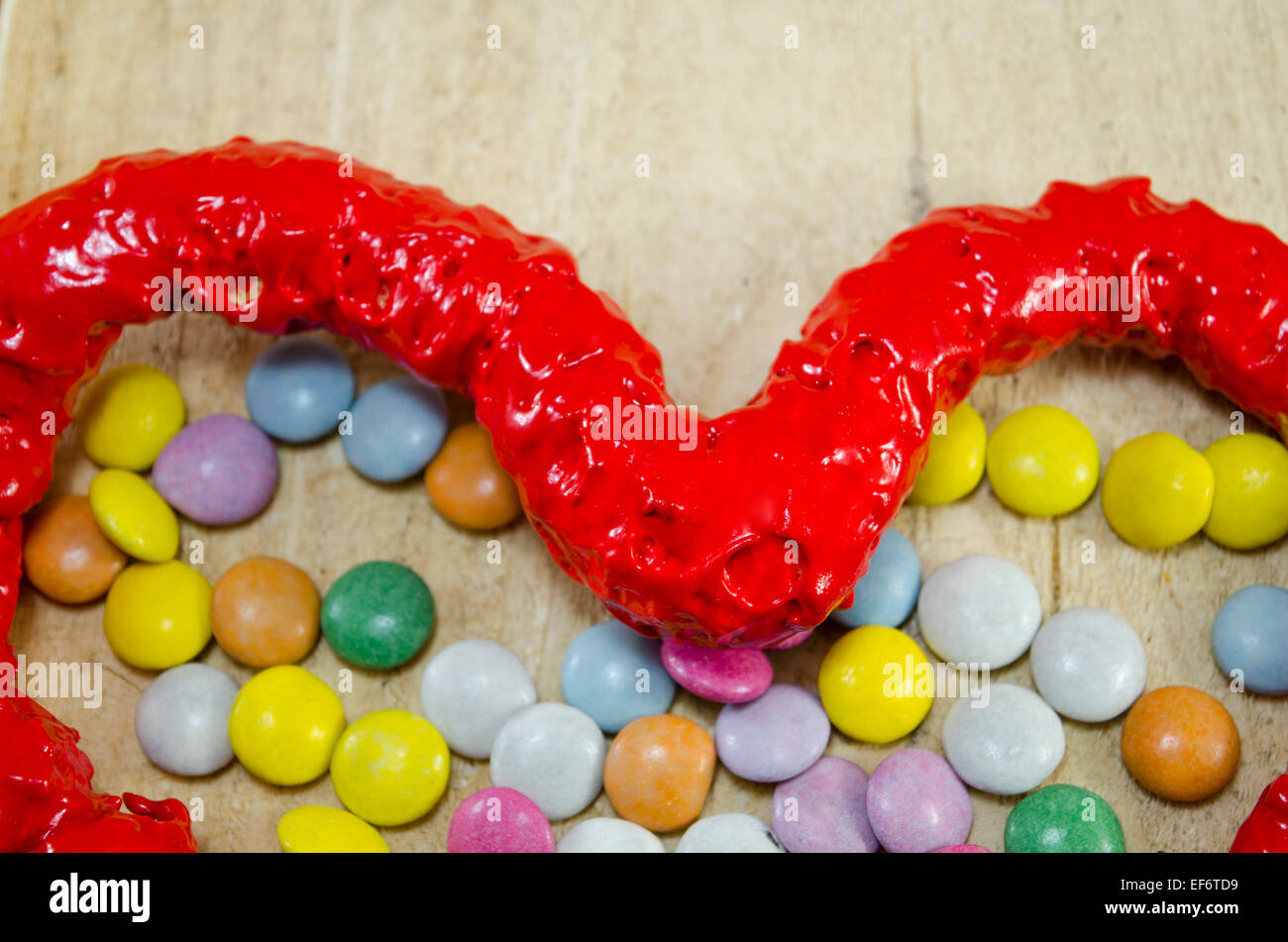 Bonbons coeur rouge et bombons bonbons colorés sur une table en bois, gros plan Banque D'Images