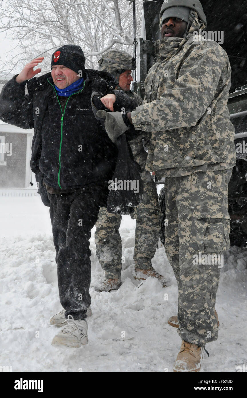 Un soldat de l'Armée américaine du Massachusetts Army National Guard aide un brin pendant l'évacuation des résidents comme Juno tempête hivernale arrête le nord-est des États-Unis avec beaucoup de neige et des vents forts, 27 janvier 2015 à Scituate, Massachusetts. Banque D'Images