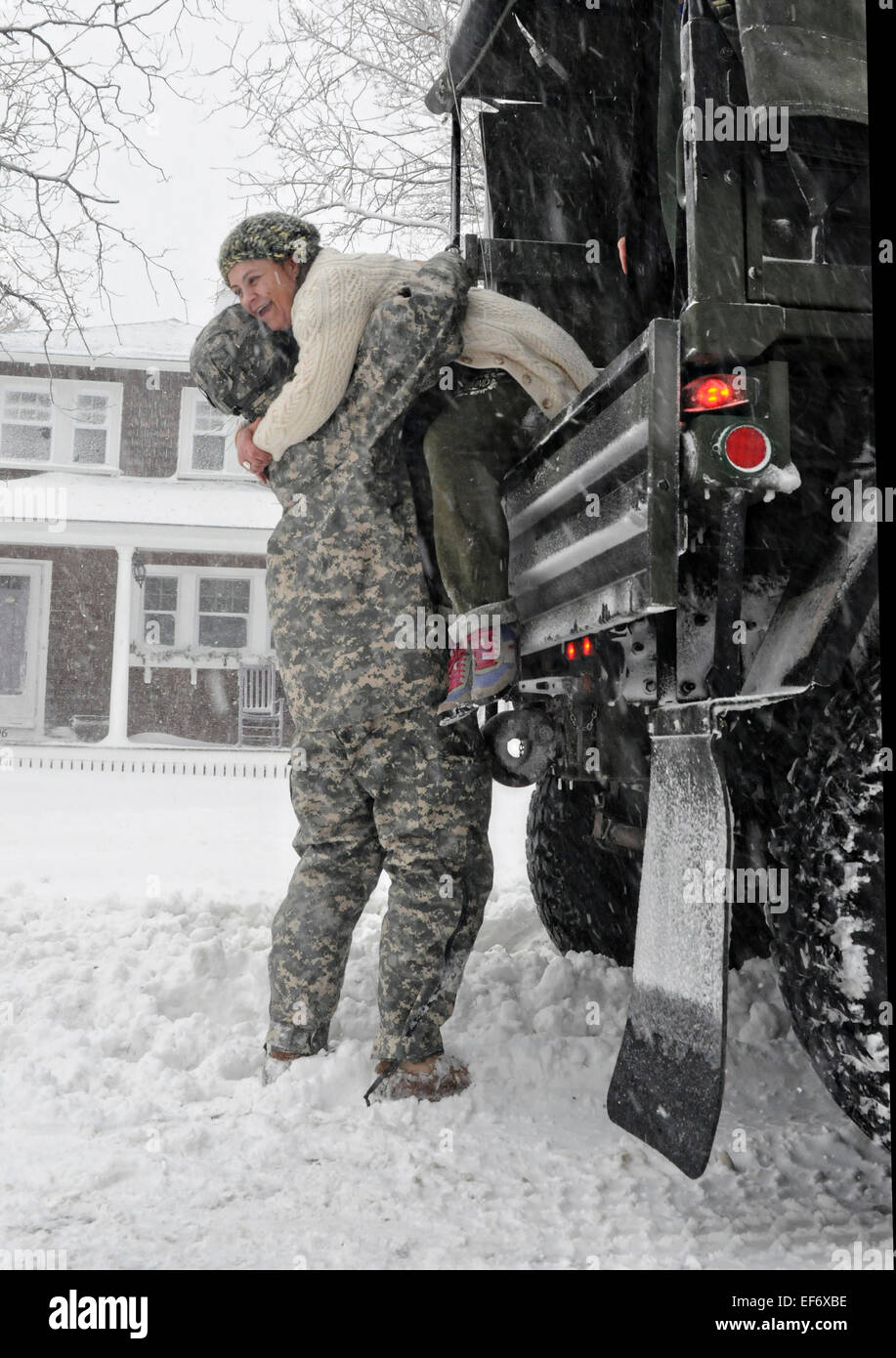 Un soldat de l'Armée américaine du Massachusetts Army National Guard aide un brin pendant l'évacuation des résidents comme Juno tempête hivernale arrête le nord-est des États-Unis avec beaucoup de neige et des vents forts, 27 janvier 2015 à Scituate, Massachusetts. Banque D'Images