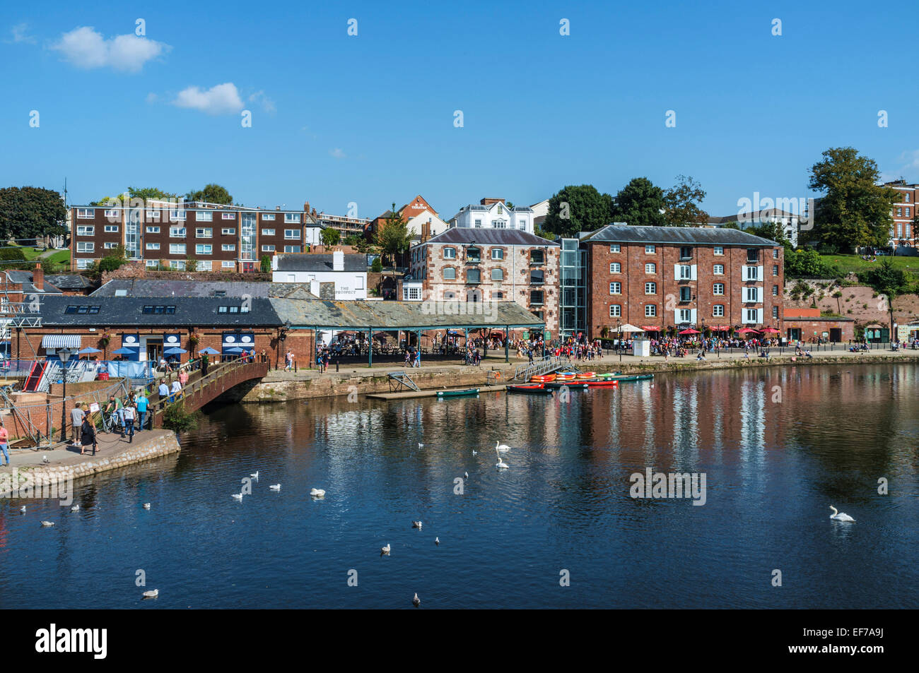 Appartements boutiques et les gens sur l'eau face à Exeter Devon UK Quays Banque D'Images