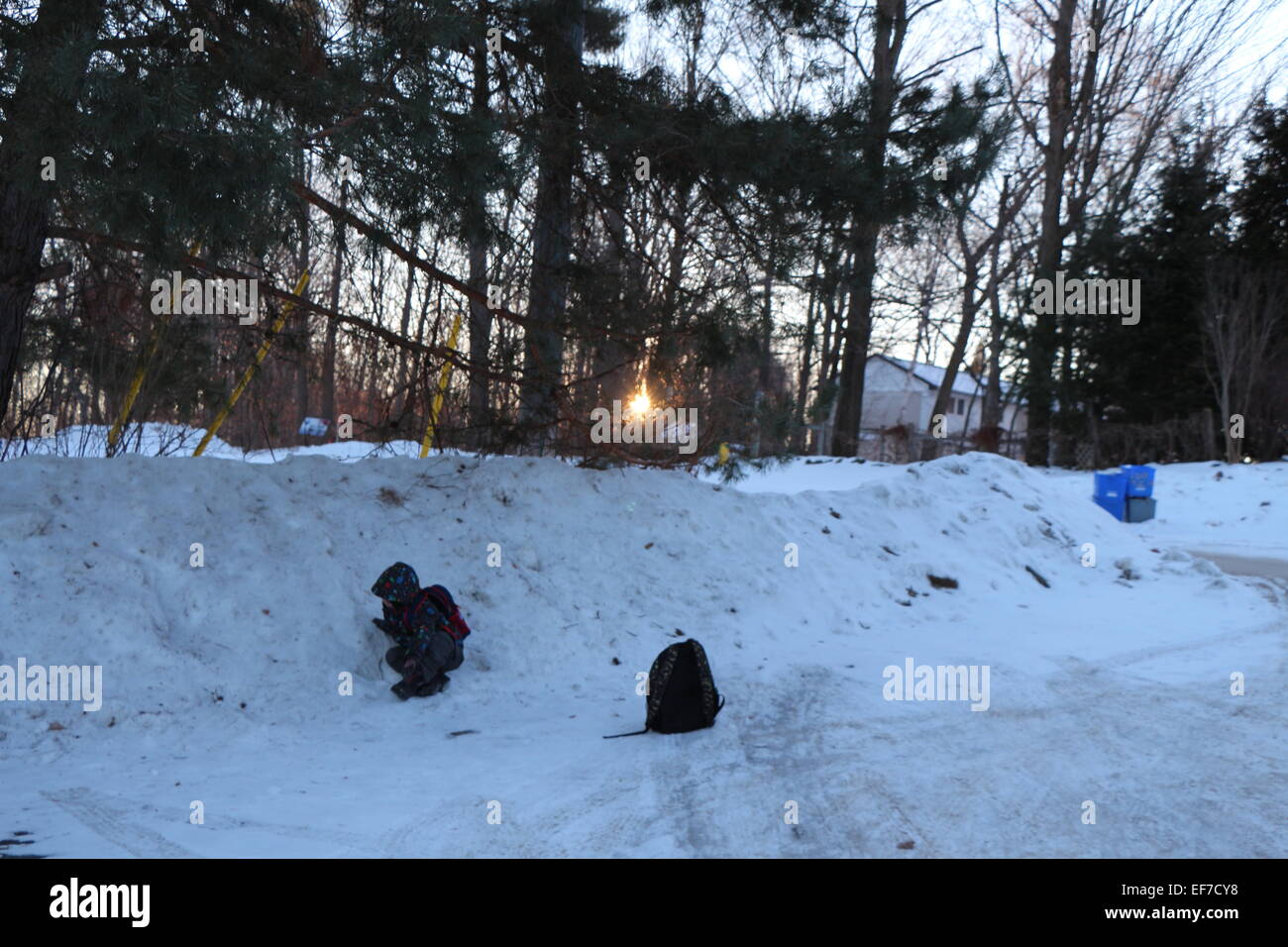 Enfant jouant dans la neige , soleils à venir Banque D'Images