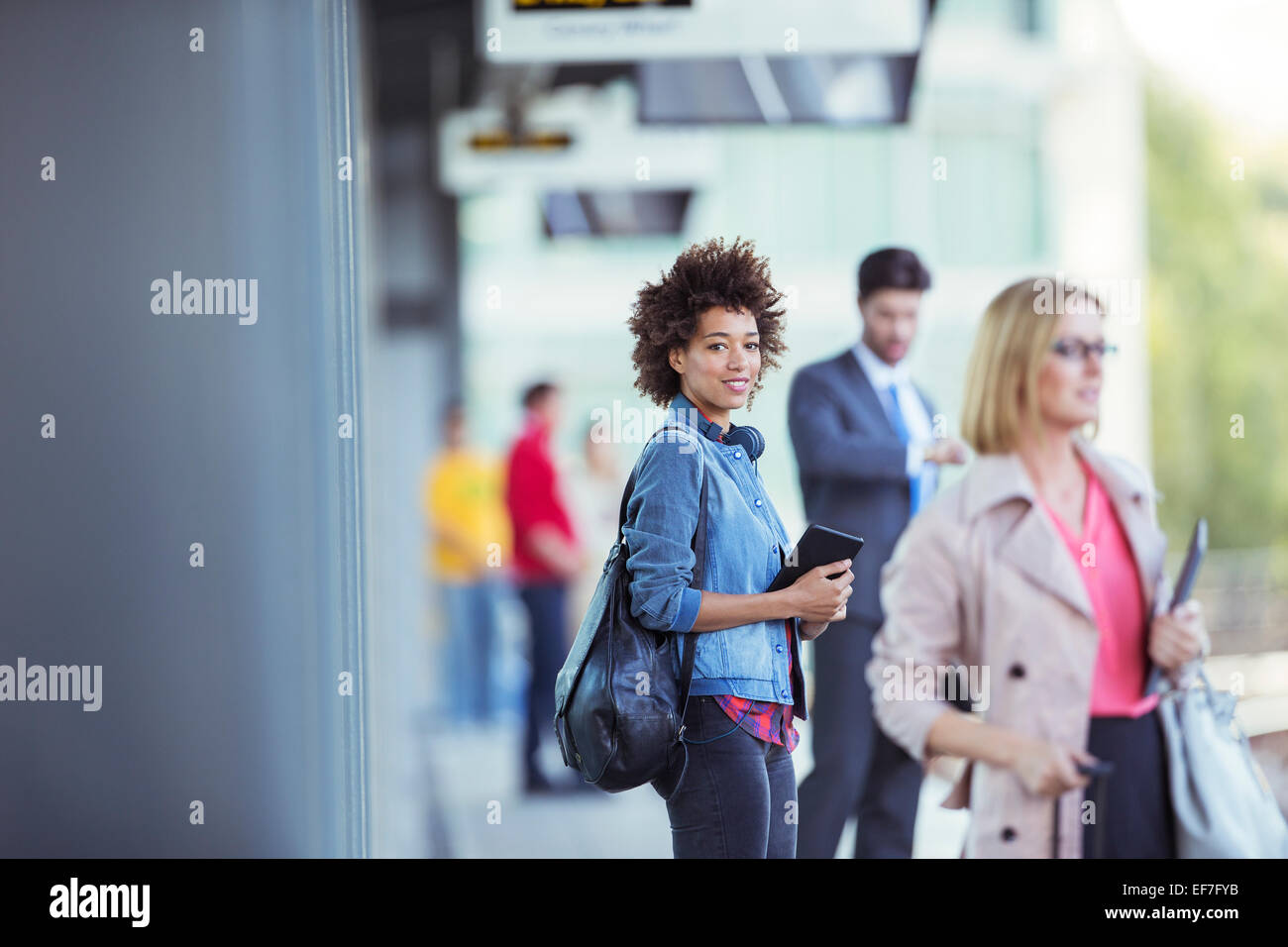 Woman holding digital tablet et en attente de train en gare Banque D'Images