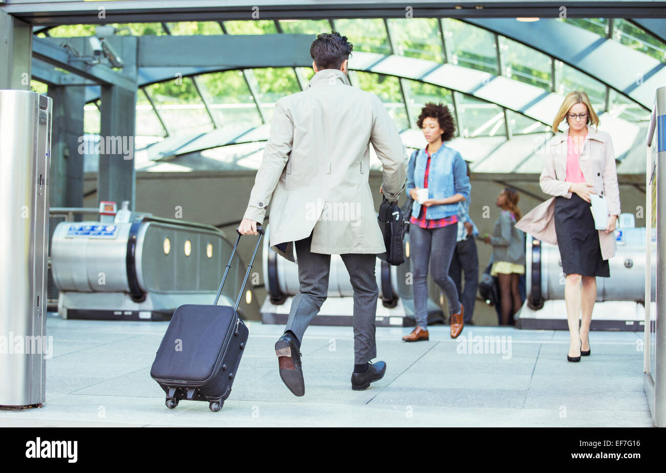Businessman pulling assurance près des escaliers mécaniques Banque D'Images