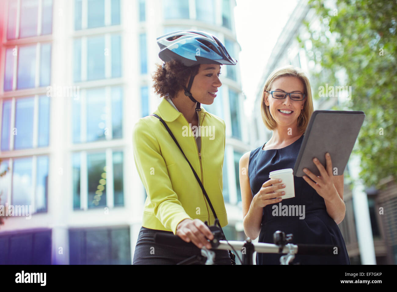 Businesswomen using digital tablet outdoors Banque D'Images