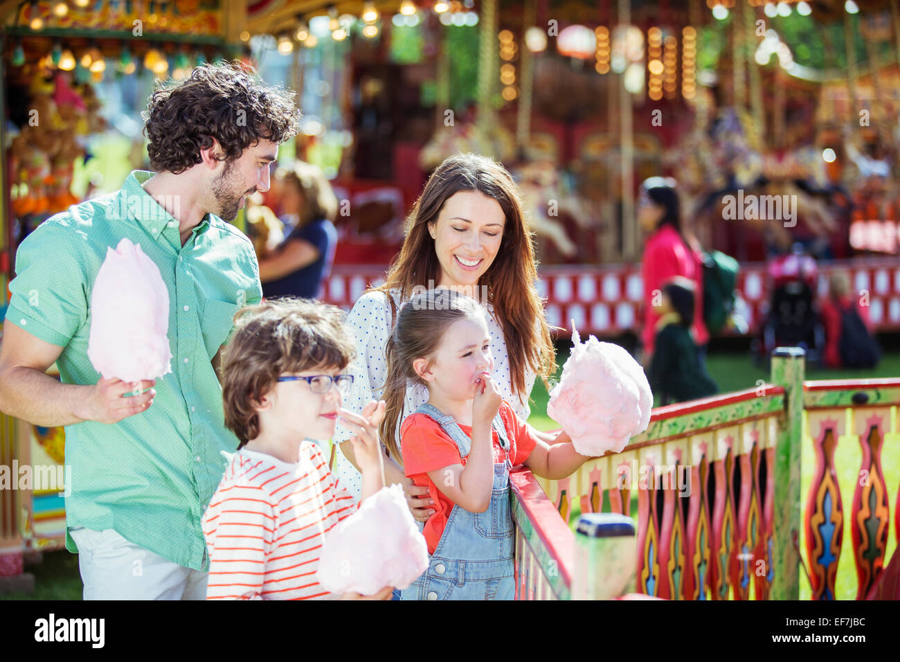 Famille avec de la barbe à papa rose en amusement park Banque D'Images