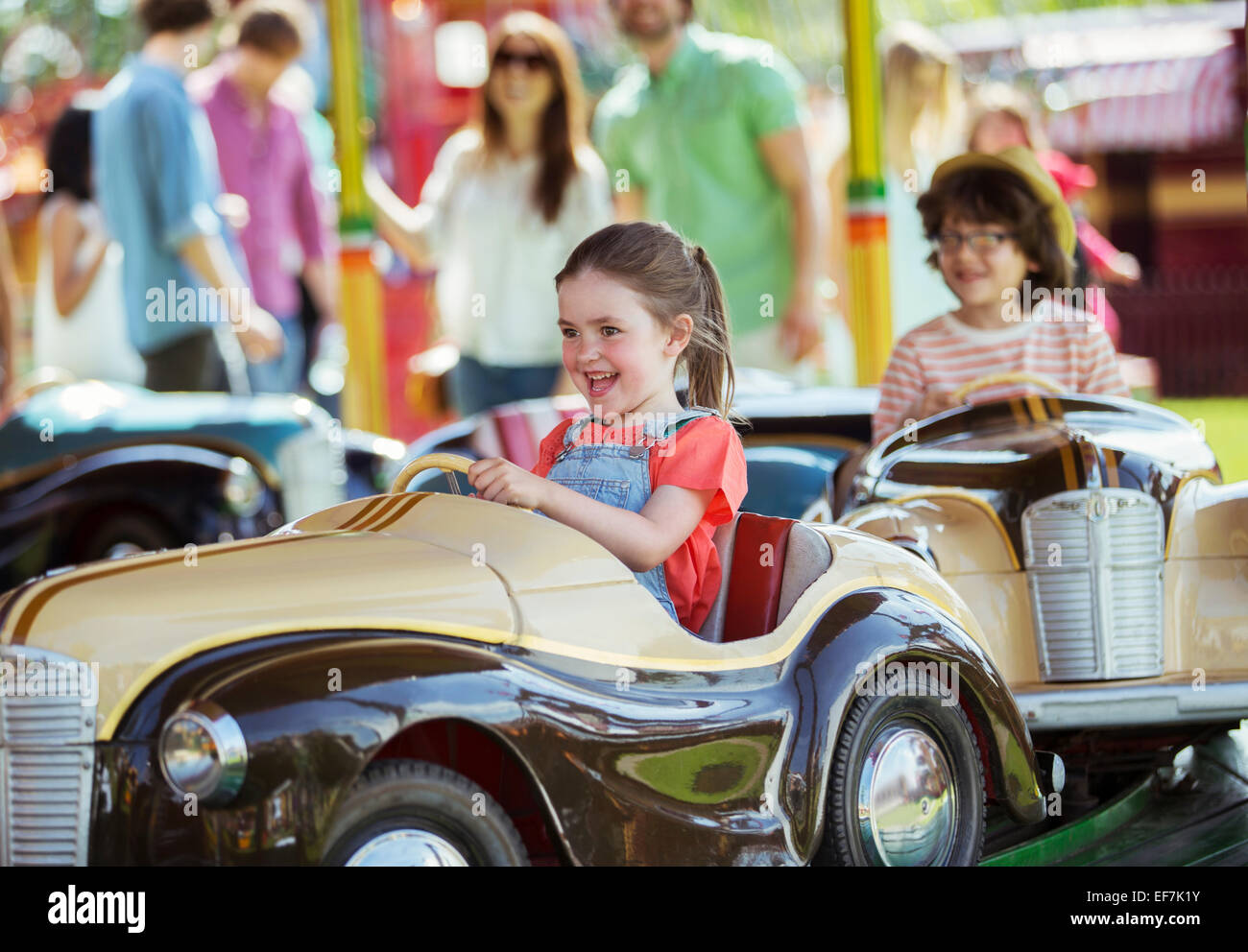 Cheerful girl sur carrousel en amusement park Banque D'Images