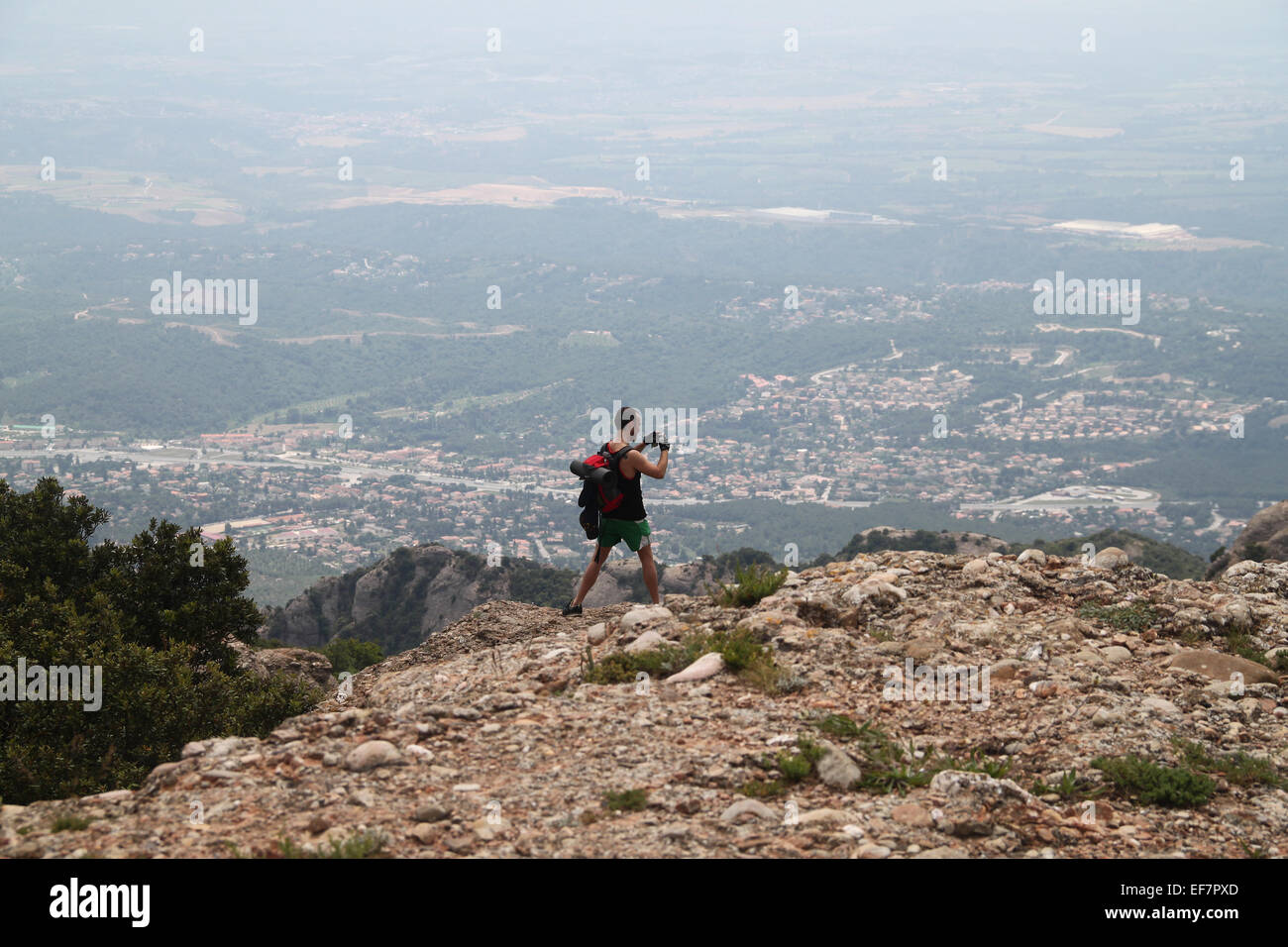 L'homme à prendre des photos de vue sur la journée brumeuse, de sommet de Sant Jeroni (1 236 m), Montserrat, en Catalogne Banque D'Images