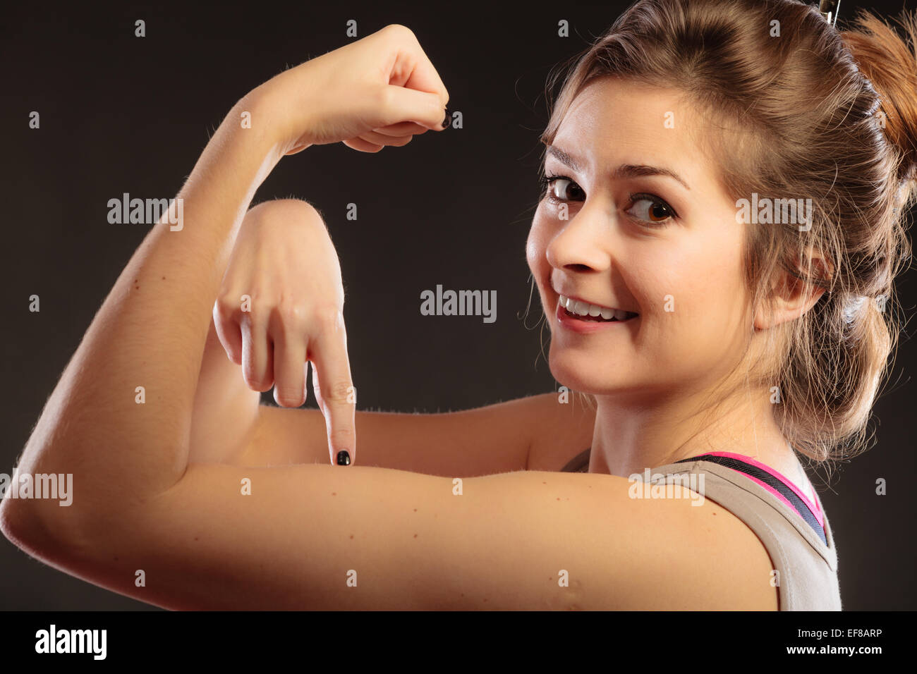 Le concept de force et de puissance. Jeune femme fille ado montrant ses  muscles sur noir Photo Stock - Alamy