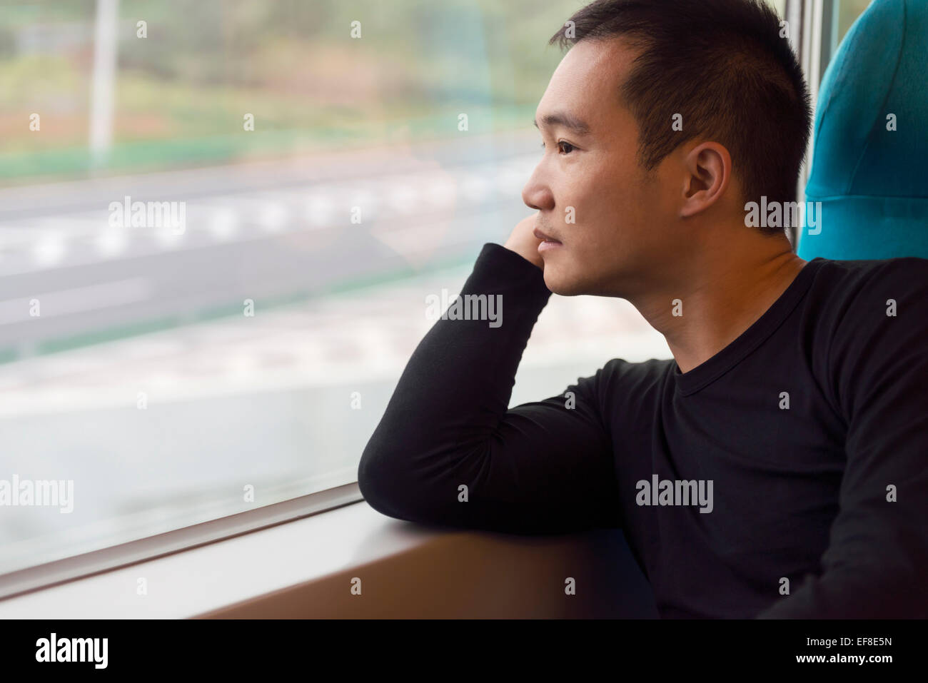 Personne à la recherche d'une fenêtre d'un train à grande vitesse de Shanghai, Chine. Banque D'Images