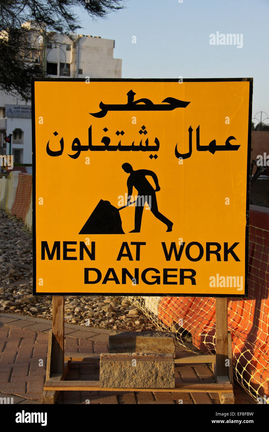 "Hommes au travail" en anglais et arabe Banque D'Images