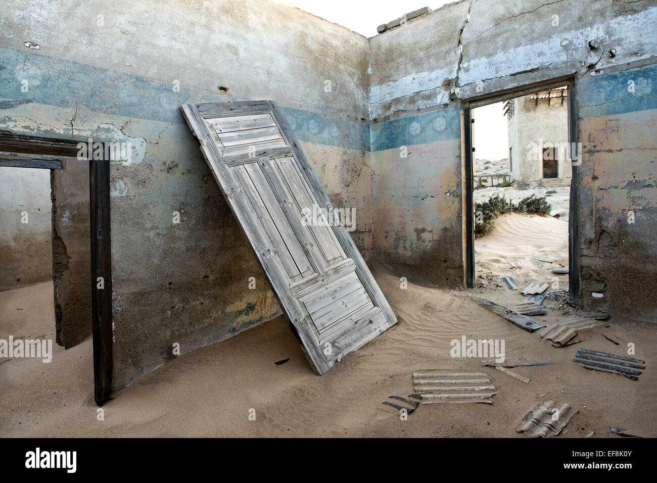 Intérieur d'un sans-abri abandonné maison avec portes et manquant de débris, qui est rempli de sable à la dérive Banque D'Images