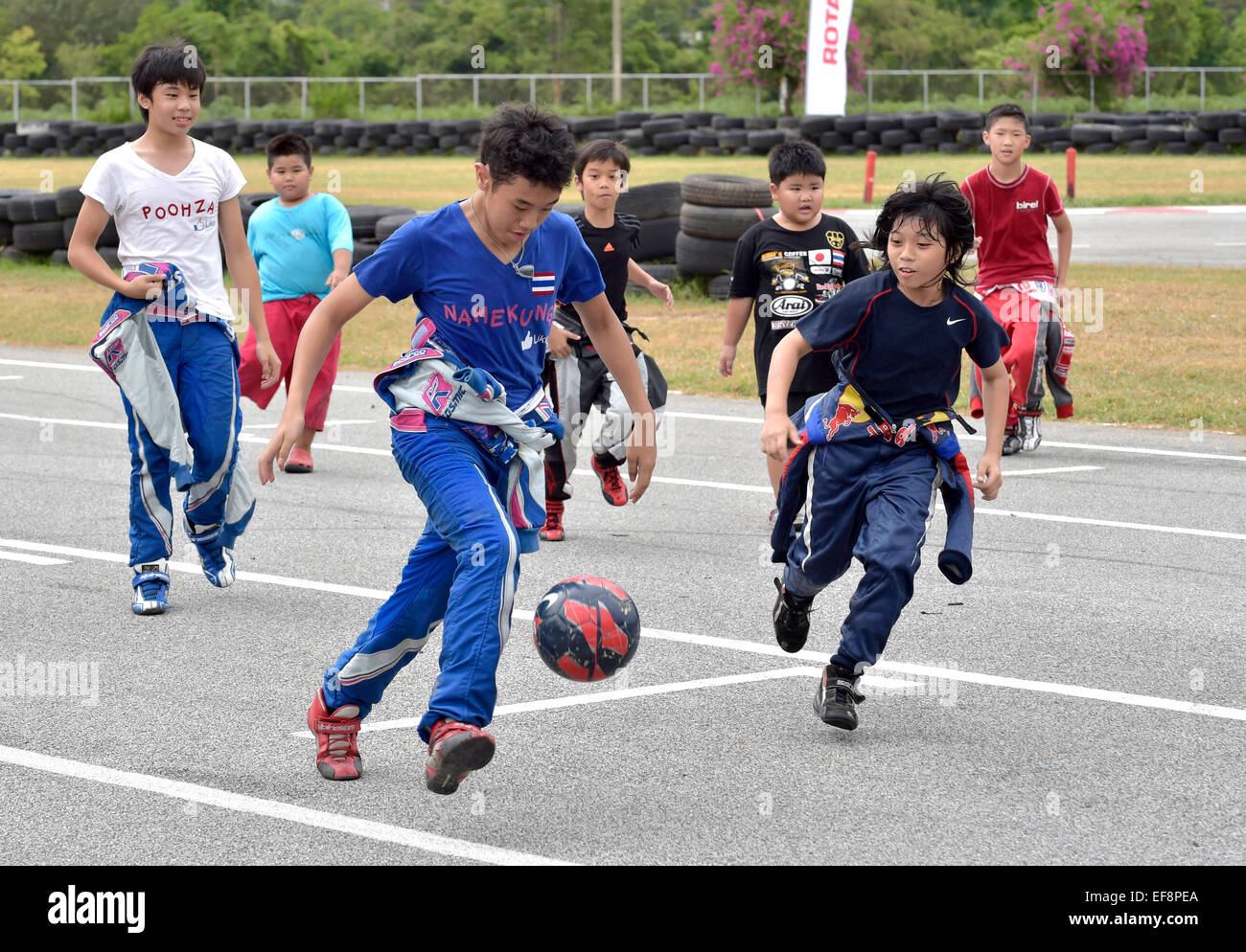Adolescent en combinaison de course jouer au football, Pattaya, Thaïlande Banque D'Images