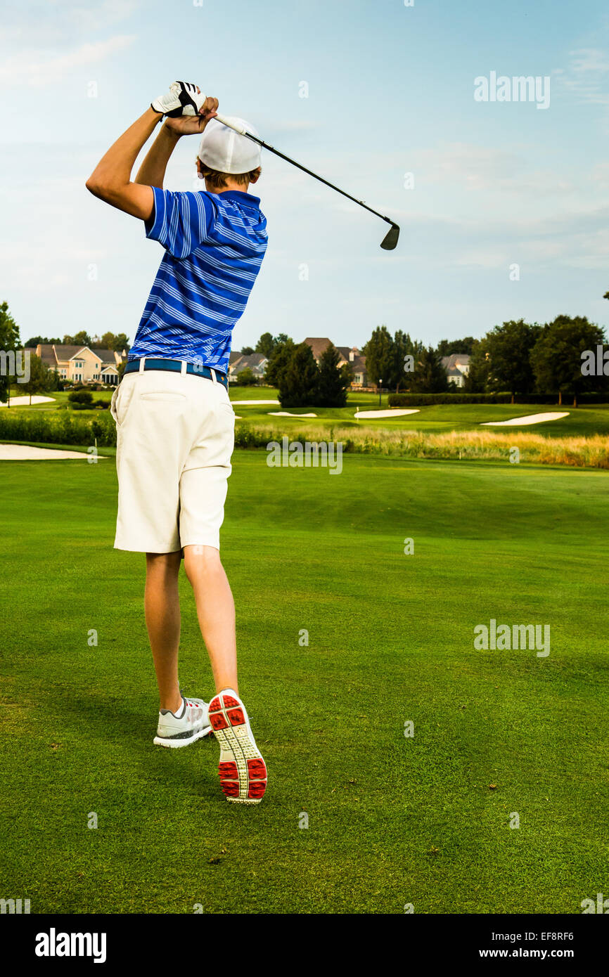 Vue arrière du teenage boy playing golf Banque D'Images