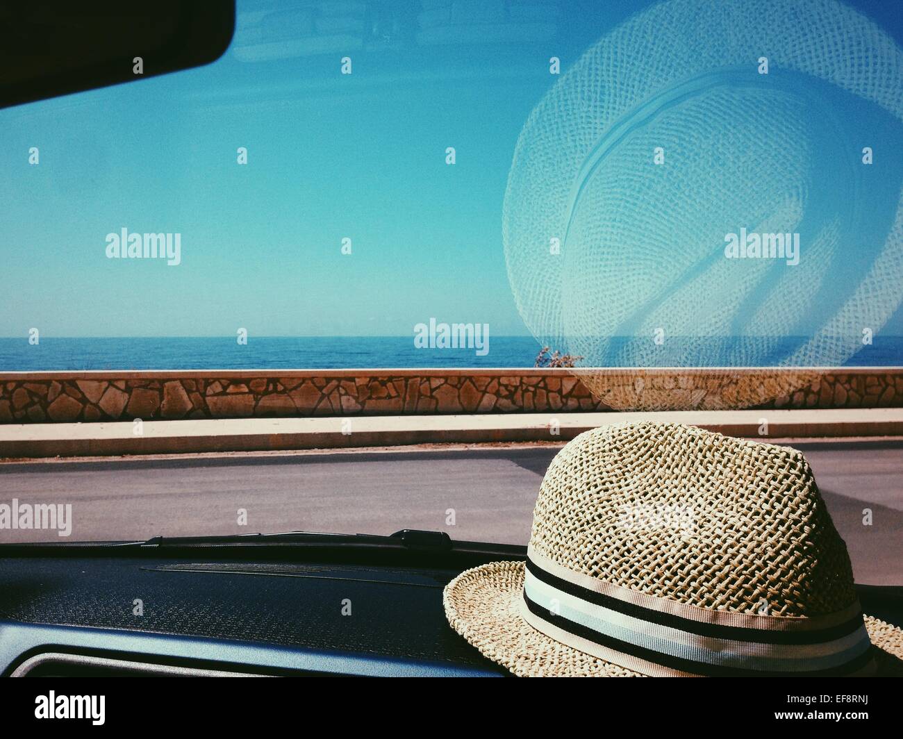 Chapeau de paille sur le tableau de bord de voiture Photo Stock - Alamy