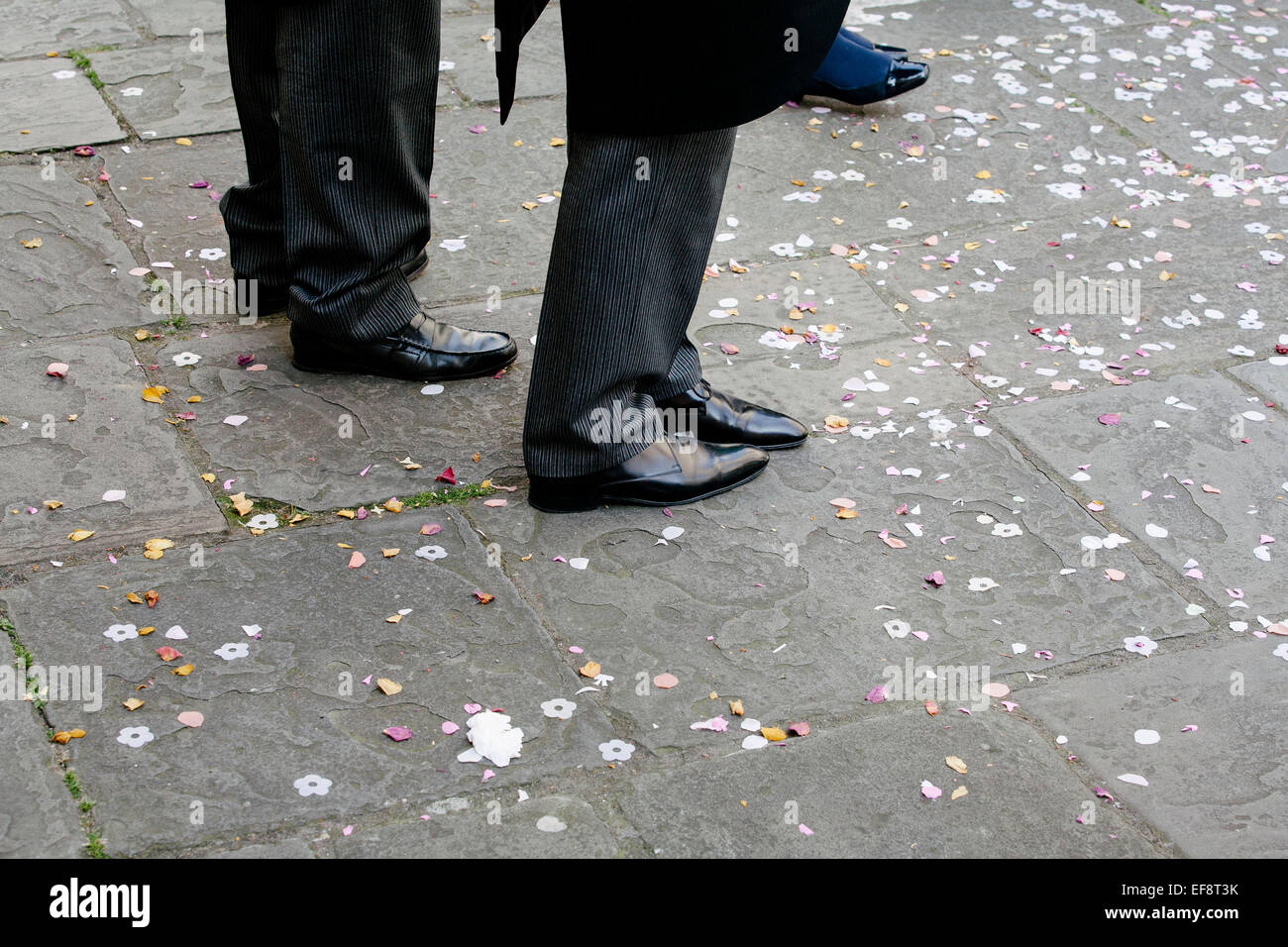 Les hommes debout de confettis sur le sol après le mariage Banque D'Images