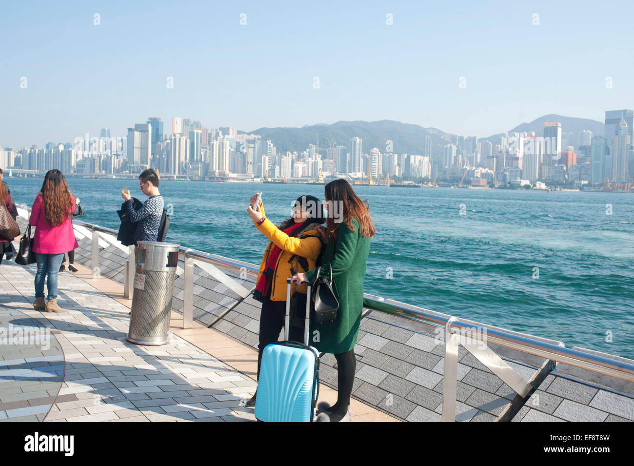 Hong Kong 2015 - Deux femmes touristes prenant une à selfies Avenue des étoiles dans Tsim Sha Tsui Banque D'Images Hong Kong 2015 - Deux femmes touristes prenant une à selfies Avenue des étoiles dans Tsim Sha Tsui Banque D'Images
