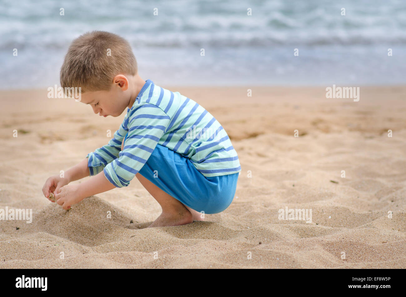 La Bulgarie, Boy (4-5) jouant sur la plage de sable Banque D'Images