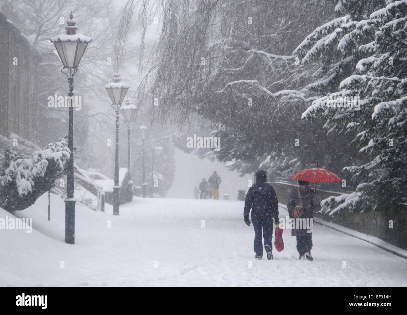 Les gens qui marchent dans la neige sur une large marche près de Pavilion Gardens, Buxton, Derbyshire, Banque D'Images