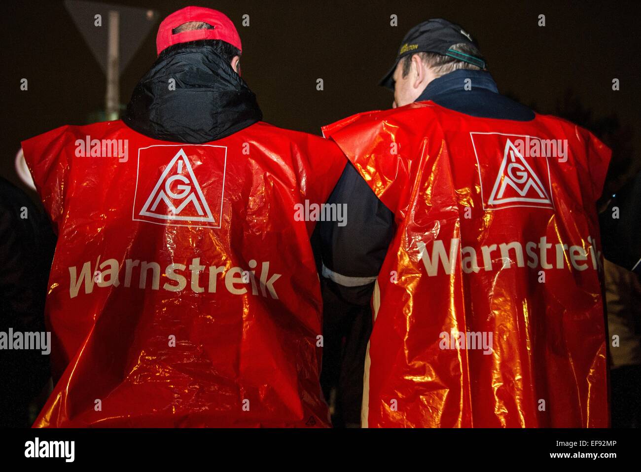 Berlin, Allemagne. 29 janvier, 2015. Deux membres du personnel du quart de nuit de constructeur automobile Mercedes-Benz de porter des vestes de grève qui dispose le logo de l'allemand de la métallurgie IG Metall et lire "grève d'avertissement" qu'elles démontrer lors d'un rassemblement organisé par l'IG Metall en face de locaux de production du constructeur automobile Mercedes-Benz à Berlin, Allemagne, 29 janvier 2015. IG Metall exige l'amélioration des revenus de 5,5 pour cent et une retraite sûre. Photo : Paul Zinken/dpa/Alamy Live News Banque D'Images