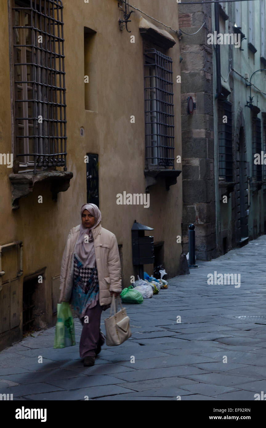 Femme musulmane portant son shopping dans le centre-ville de Lucca, Toscane, Italie Banque D'Images