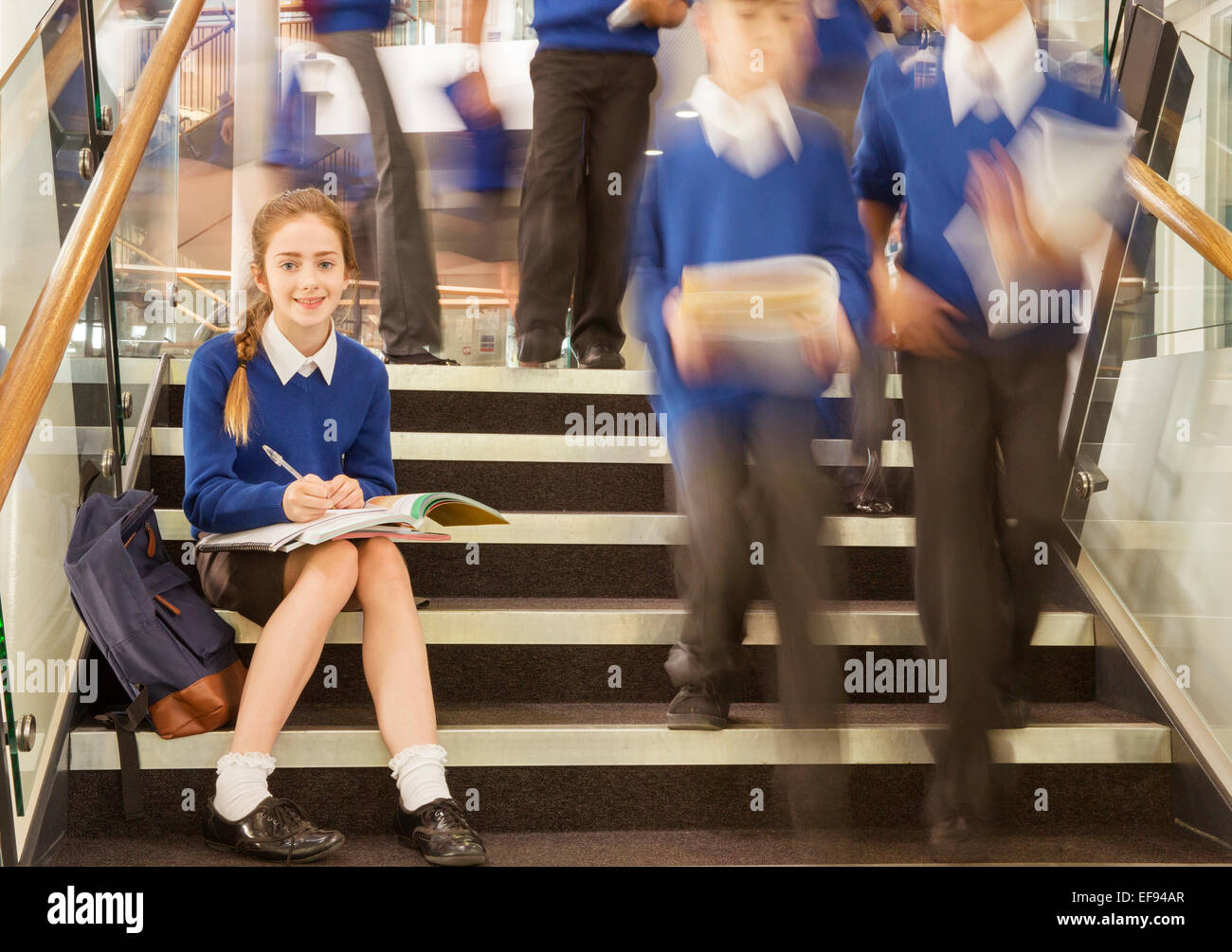 Portrait of elementary school girl sitting on steps à l'école Banque D'Images