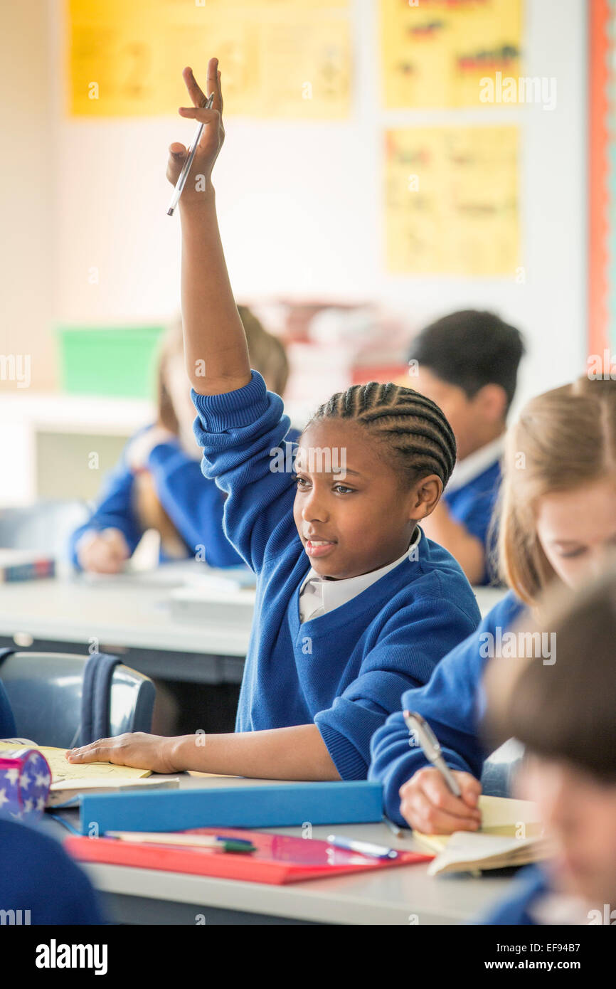 Les enfants de l'école élémentaire en classe pendant la leçon, girl raising hand Banque D'Images