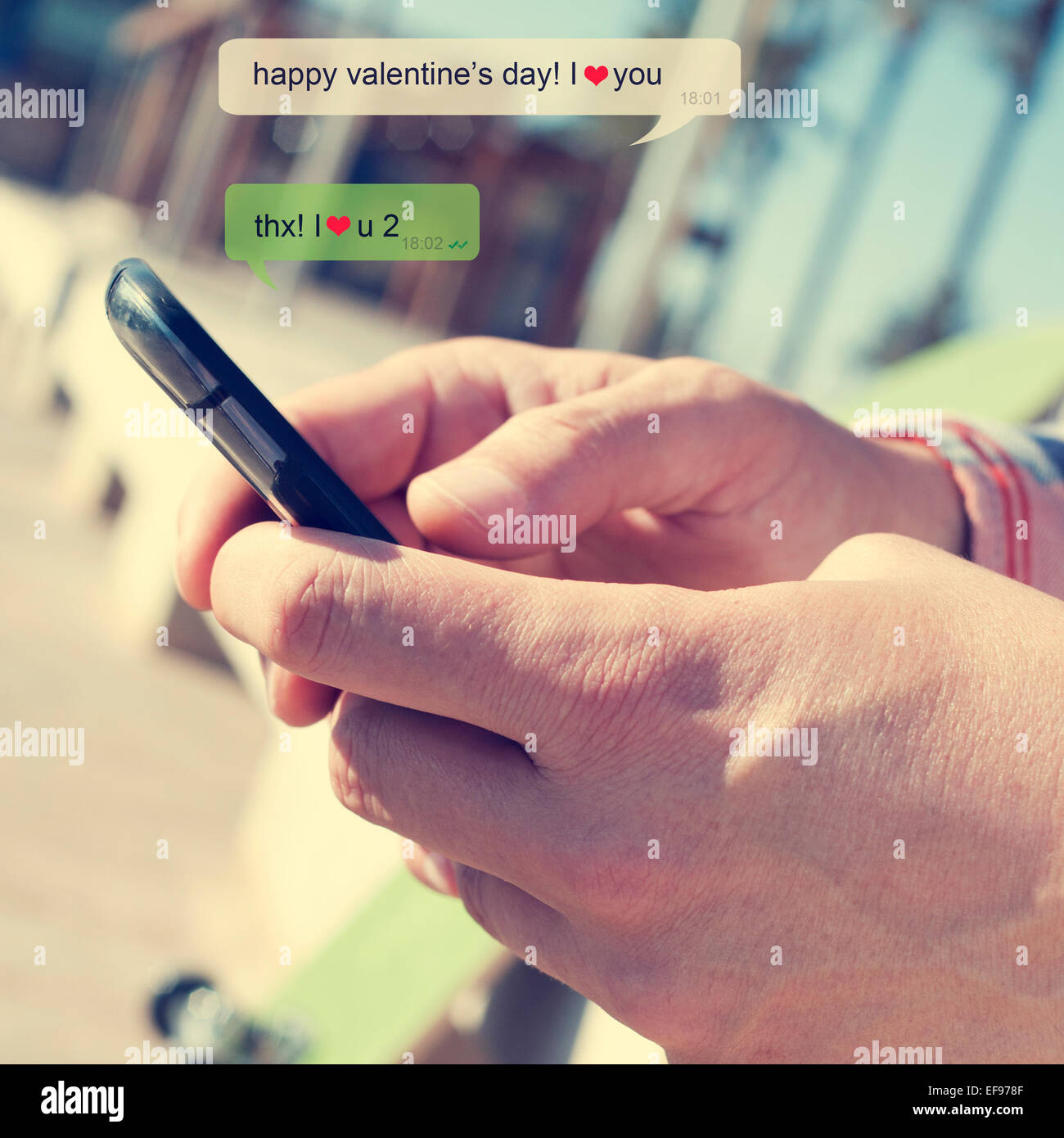 Un jeune homme l'envoi d'un message texte avec un smartphone avec le texte Happy valentines day, je vous aime Banque D'Images