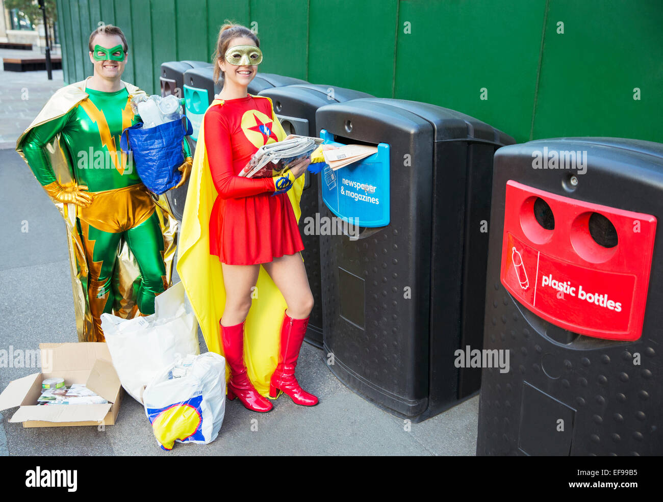 Couple de super-héros sur le trottoir de la ville de recyclage Banque D'Images