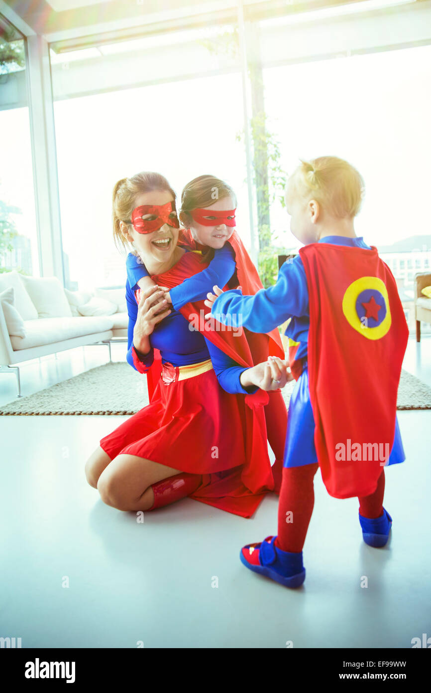 Mère de super-héros et les enfants qui jouent dans la salle de séjour Banque D'Images