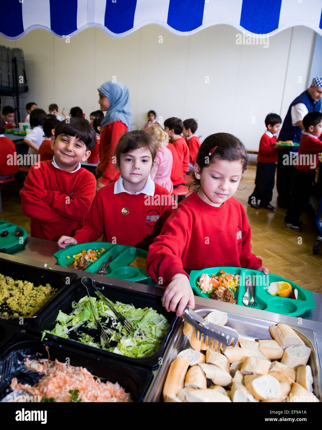 À l'heure du déjeuner de l'État britannique les enseignants du primaire et les enfants de l'école primaire à l'école primaire Banque D'Images