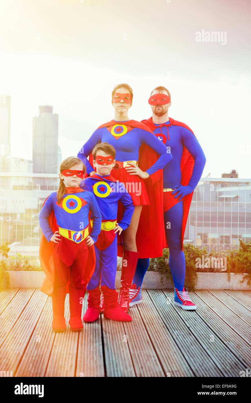 La famille de super-héros debout sur les toits de la ville Banque D'Images