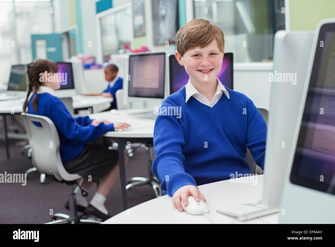 Les enfants de l'école primaire travaillant avec les ordinateurs Banque D'Images