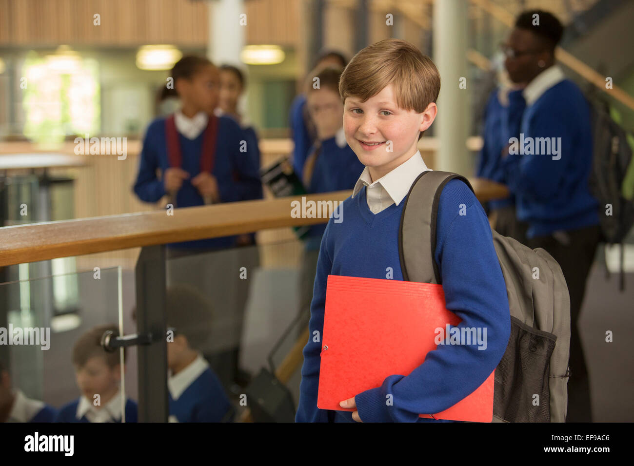 Portrait of elementary school boy wearing blue school uniform standing in school corridor Banque D'Images