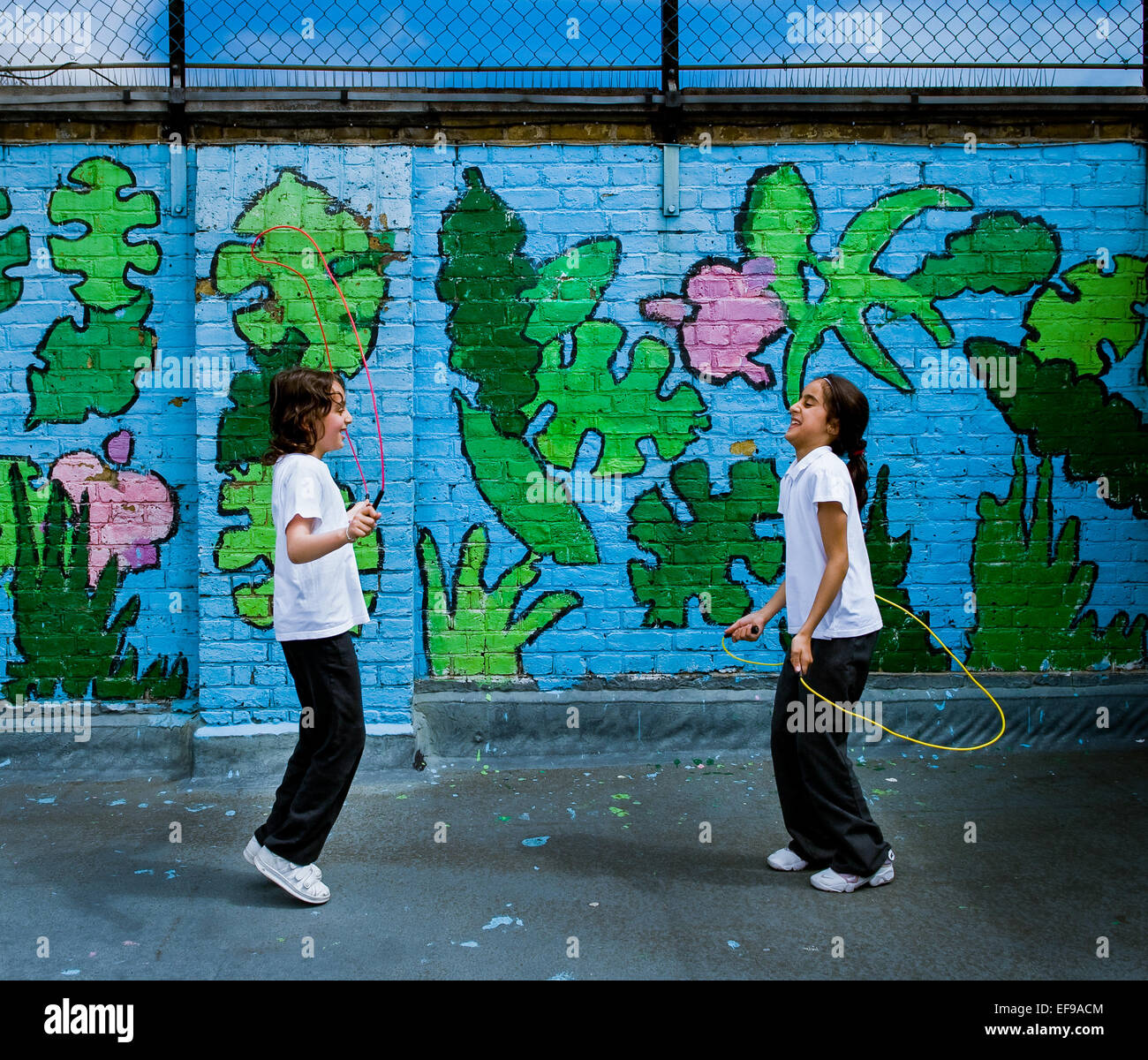2 filles sautant dans heureux d'école à Paddington, Londres Banque D'Images