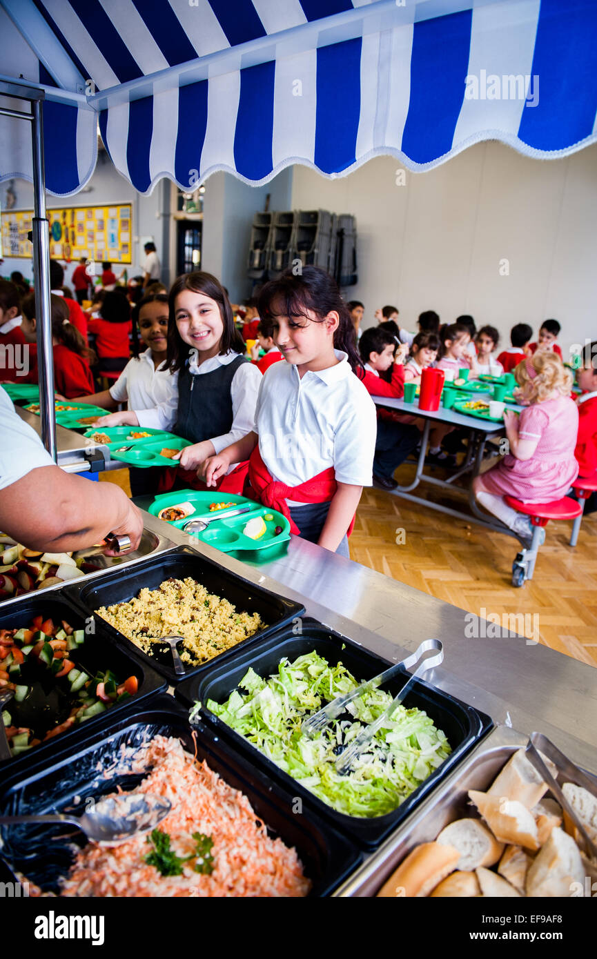 À l'heure du déjeuner de l'État britannique les enseignants du primaire et les enfants de l'école primaire à l'école primaire Banque D'Images