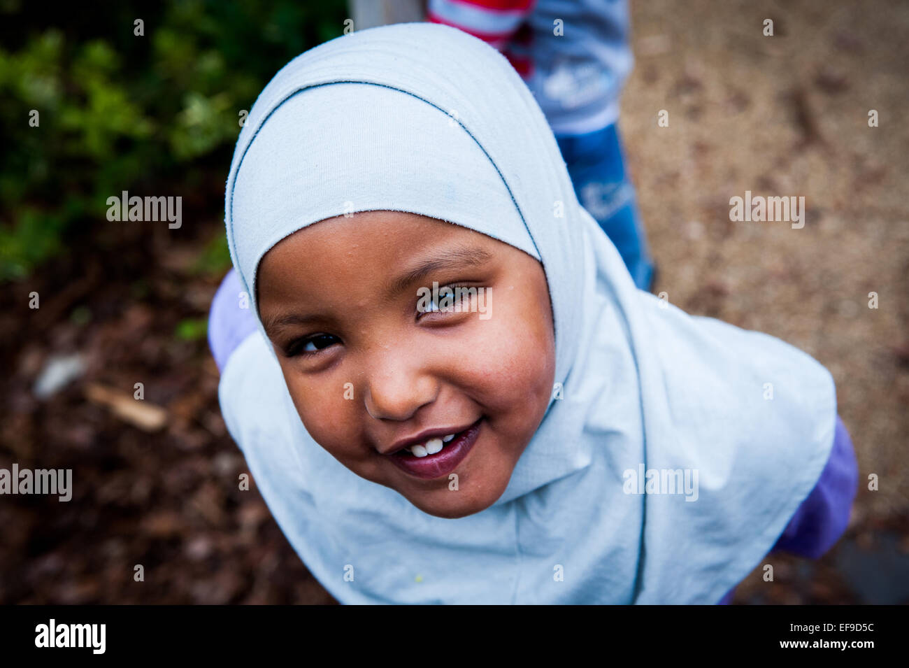Happy Smiling fille musulmane en foulard dans l'aire de jeux de l'école primaire de Londres W2 Banque D'Images