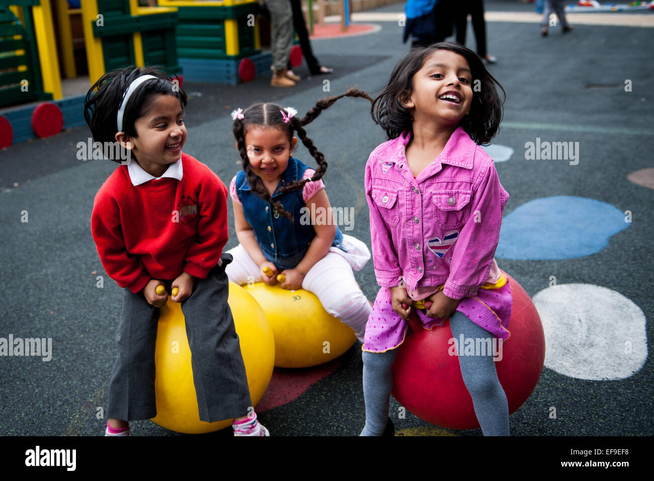 Pour rebondir sur Spacehoppers dans l'aire de jeux de l'école primaire de Londres W2 Banque D'Images