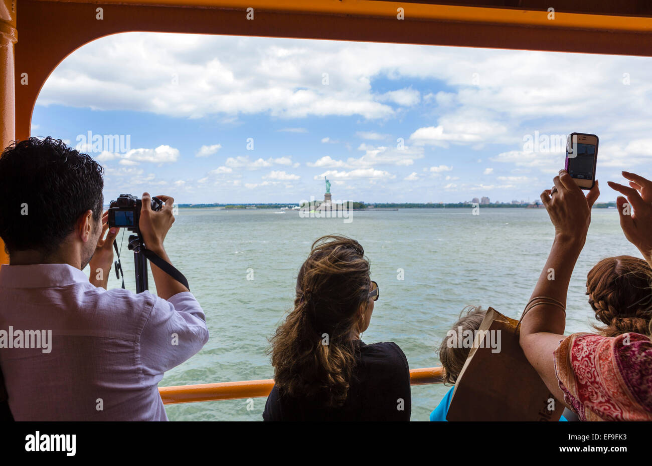 Les passagers à bord du ferry pour Staten Island pour prendre des photos de la Statue de la liberté, New York, NY, USA Banque D'Images