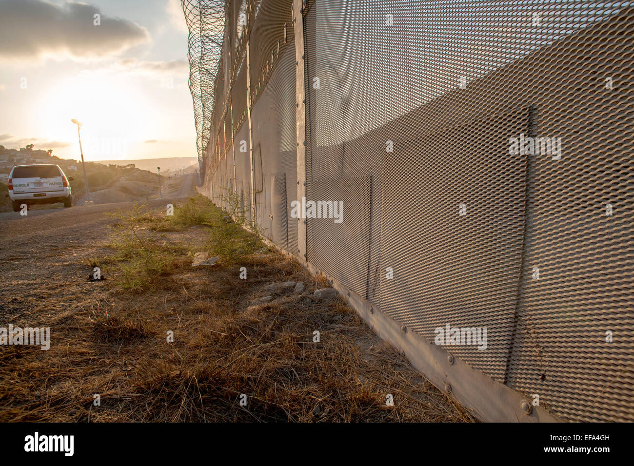 Corrigé des trous dans la clôture internationale sur la frontière États-Unis/Mexique en face de la Colonia Libertad district de Tijuana, Mexique voir les endroits où les immigrants illégaux ont tenté d'entrer aux États-Unis Remarque barbelés sur le dessus de la clôture et Border Patrol SUV dans l'arrière-plan. Banque D'Images