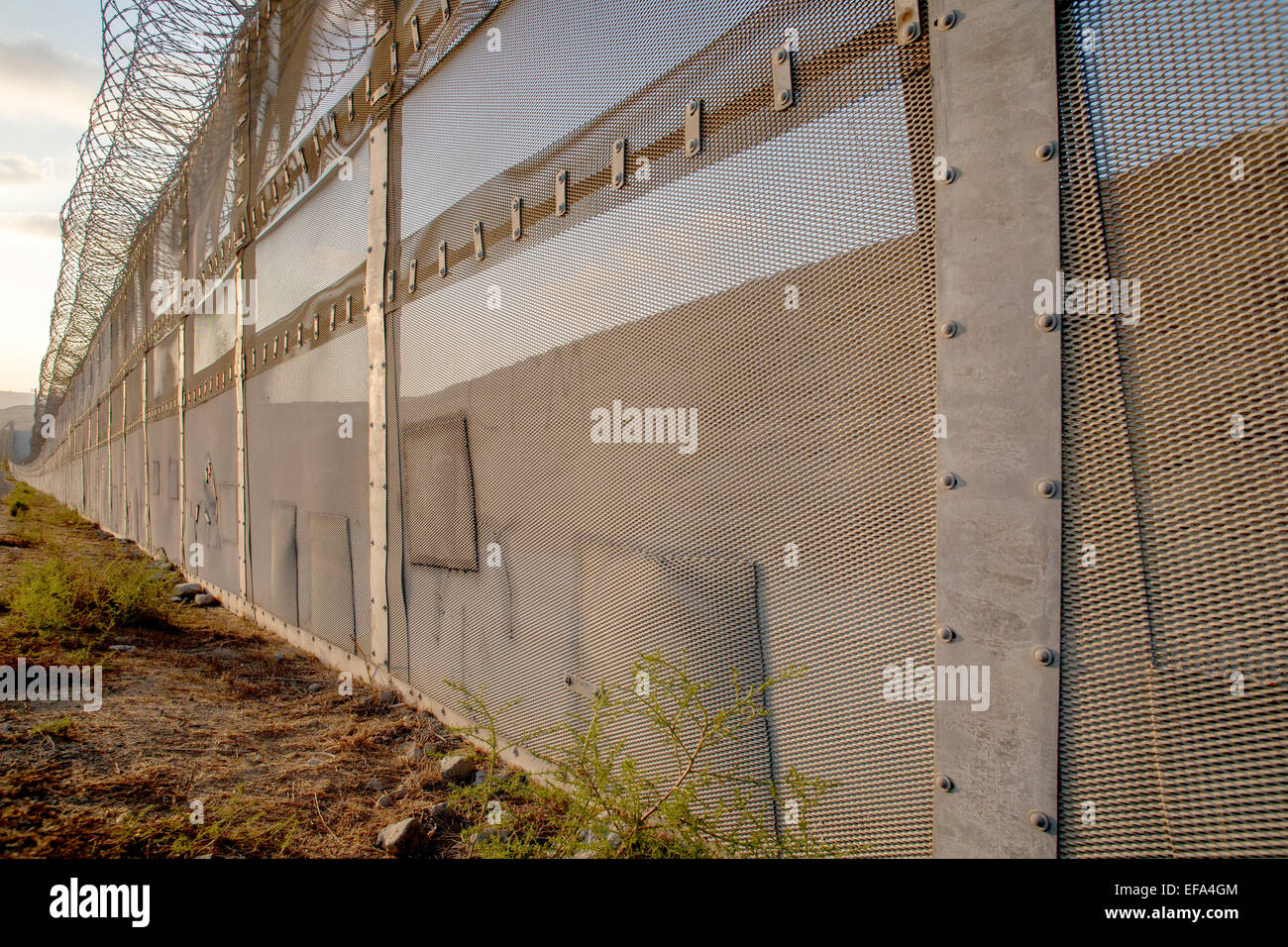 Corrigé des trous dans la clôture internationale sur la frontière États-Unis/Mexique en face de la Colonia Libertad district de Tijuana, Mexique voir les endroits où les immigrants illégaux ont tenté d'entrer aux États-Unis Remarque barbelés sur le dessus de la clôture. Banque D'Images